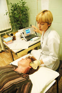 Врач функциональной диагностики Оксана Некрасова проводит ультразвуковую допплерографию сосудов шеи и мозга.