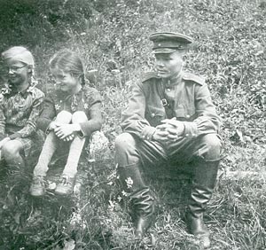 Лейтенант Тимофей Клементьев. Рядом с ним за учениями батальона наблюдают немецкие девочки (июнь 1945 года).