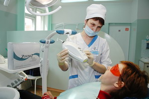 Врач-стоматолог Елена прокопьева за аппаратом отбеливания “Zoom-2”.