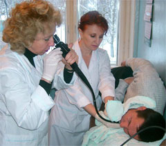 Заведующая эндоскопическим отделением А.Викторова и старшая медсестра А.Васильева обследуют больного. Фото Валерия Бакланова.