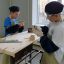 12-летний Иван Суворов (в белой футболке) из Йошкар-Олы и его товарищ мастерят коробочки из деревянных дощечек в столярной мастерской. 