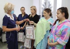 Врач акушер-гинеколог НМЦ Надежда Табаева (слева) вручает подарки маме новорожденного Светлане Сафрончевой. Фото Максима БОБРОВАРожденные в вышивке День чувашской вышивки 