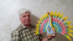 Владимир Адушев с павлином, сделанным из разноцветной бумаги.Картины, иконы, куклы... просятся в люди