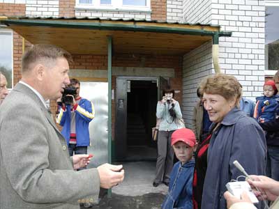 В.Артемьев поздравляет новосела Т.Матвееву. Фото Валерия Бакланова.