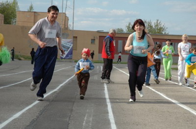С эстафетной палочкой самые юные участники в сопровождении мам и пап. Фото Валерия Бакланова.